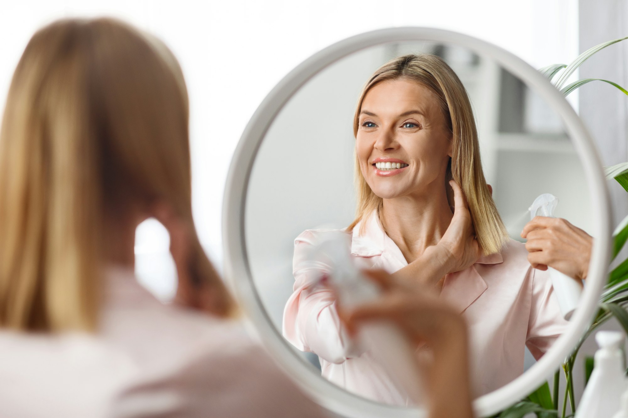 Beautiful Middle Aged Woman Applying Moisturising Hair Spray On Ends