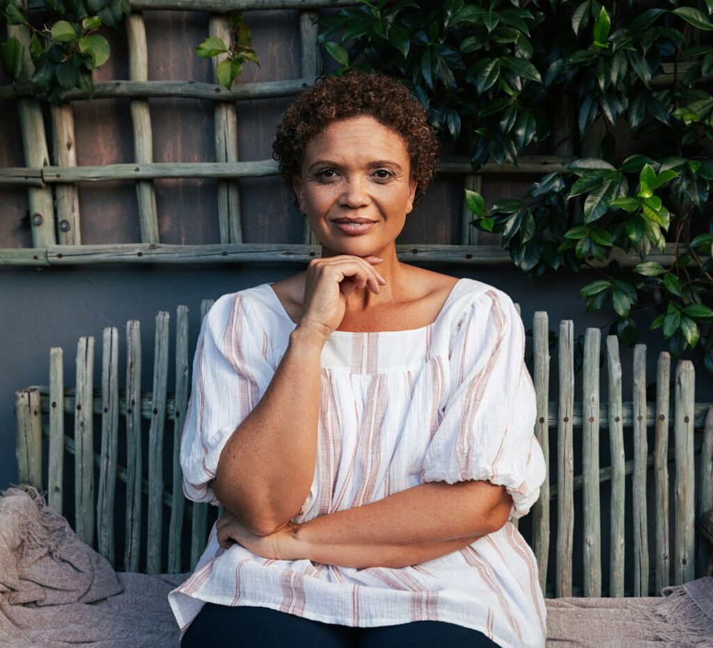 Portrait of a middle aged woman sitting on bench looking at camera