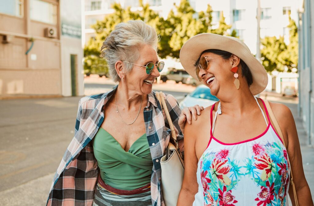 Happy, senior women and laugh in city for walking, travel and bonding on vacation and urban backgro